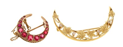 Lot 510 - Gold and diamond crescent brooch and a Victorian gold and red stone crescent brooch (2)