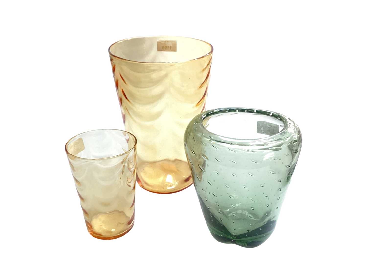 Lot 1195 - Two Whitefriars Marriott Powell amber wave ribbed tumbler vases, together with a sea green controlled bubble vase (3)