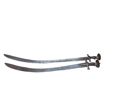 Lot 987 - Two 19th century Indian Tulwars with traditional disc hilts and curved fullered blades