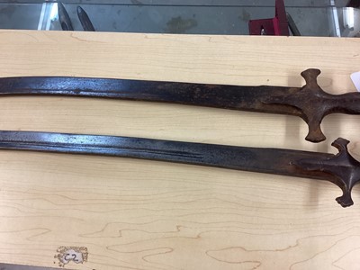 Lot 987 - Two 19th century Indian Tulwars with traditional disc hilts and curved fullered blades