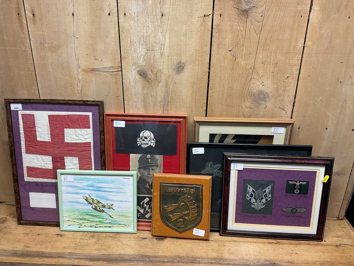 Lot 810 - Group of seven Nazi German items mounted in glazed frames, to include reproduction poster, drawing of an ME 262, reproduction arm bands and insignia (7).