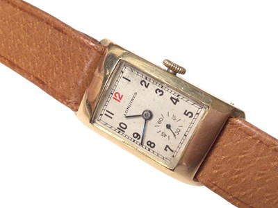 Lot 282 - 1930's 9ct gold Longines tank wristwatch with silvered dial, Arabic numeral hour markers and subsidiary seconds dial, on a brown leather strap, case approximately 20mm in diameter.