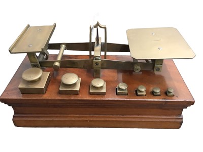 Lot 2542 - Pair Victorian brass postal scales by Ratcliff on stepped mahogany plinth 26.5cm wide complete with set of brass square graduated weights