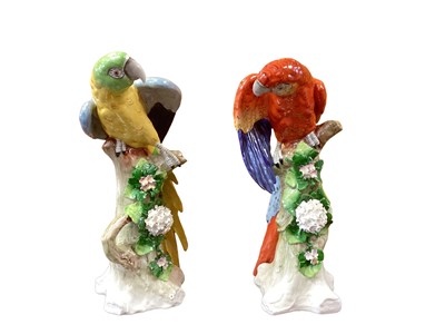 Lot 1258 - Pair of Sitzendorf porcelain macaws perched on branches