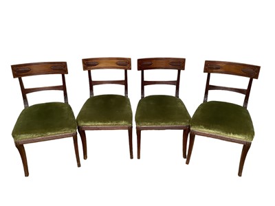 Lot 1324 - Set of four late Regency Grecian-Revival carved mahogany dining chairs