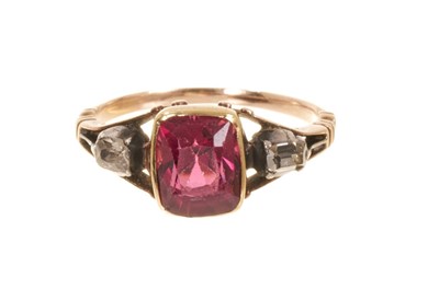 Lot 500 - Georgian garnet and diamond three stone ring with a cushion cut garnet flanked by two old cut diamonds in collet setting with scalloped gold back and pierced scroll shoulders on tapered shank, ring...