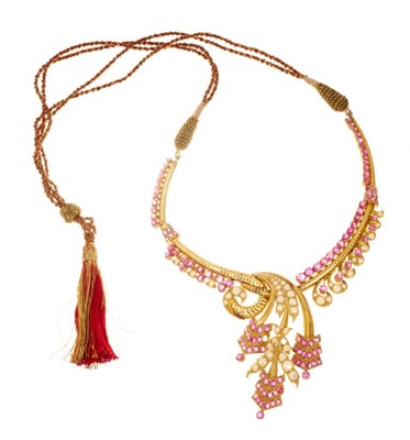 Lot 552 - Indian gold ruby and pearl necklace with a stylized floral scroll, set with graduated mixed cut rubies and pearls, in high carat gold setting with cord