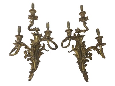 Lot 835 - Pair of rococo style ormolu three branch wall lights, approximately 51cm high