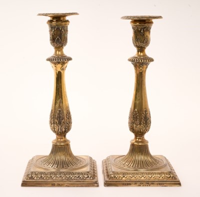 Lot 435 - Pair of Edwardian silver gilt candlesticks with detachable sconces, baluster stems decorated with acanthus leaves, on a square foot, by Harrison Brothers & Howson (George Howson). Sheffield 1911, h...