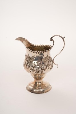 Lot 438 - George III silver cream jug of baluster form with repoussé floral swags on pedestal foot, London 1769, height 11cm.