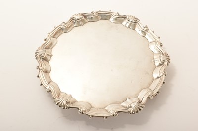 Lot 449 - George II silver salver with piecrust edge, shell and scroll border on three hoof feet, by William Peaston, London 1754.