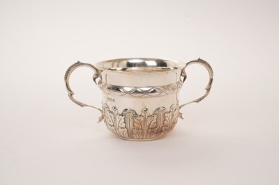 Lot 450 - Late 17th century style silver porringer with two beaded scroll handles and repoussé acanthus leaves, London 1918, 16cm wide x 8.5cm high, 5.5oz