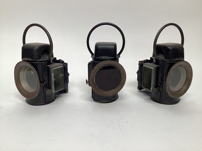 Lot 2642 - A set of three traction engine/commercial locomotive vehicle oil-illuminating side and rear lamps, by Sherwood Ltd, 1920s, black painted cylindrical bodies, with 3 inch glass lenses with nickelled...