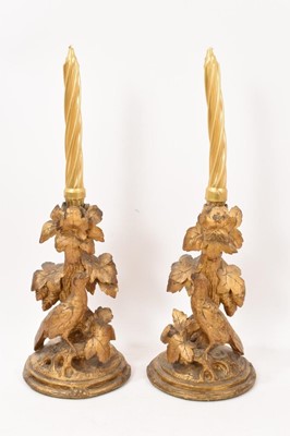 Lot 706 - Pair of late 19th / early 20th century Black Forest carved giltwood candlesticks