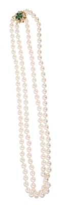 Lot 458 - Cultured pearl two-strand necklace with an emerald and diamond clasp