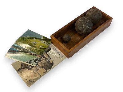 Lot 731 - Two cannon balls and a piece of grape shot. Provenance- the balls and grape shot were dug up in the grounds of Pendennis Castle, the location of them is marked on a postcard included in lots.