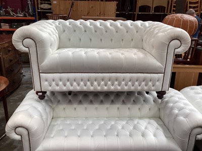 Lot 1313 - Chesterfield white leather three seater settee, two seater settee, armchair and foot stool, with labels for Sofa by Saxon (4)