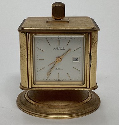 Lot 2622 - A Looping brass cased table clock, with thermometer, barometer, and hygrometer, the whole encased in a cube, raised on a rotating conical base, 6.5cm diameter