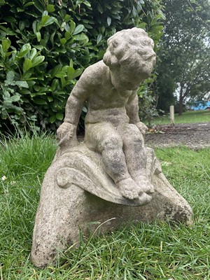 Lot 246 - Old reconstructed stone garden ornament of a seated putti