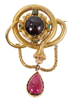 Lot 461 - Victorian gold garnet and emerald snake brooch, the coiled gold snake with a central cabochon garnet and four emeralds, suspending a pear-shape cabochon garnet pendant drop, 57mm.