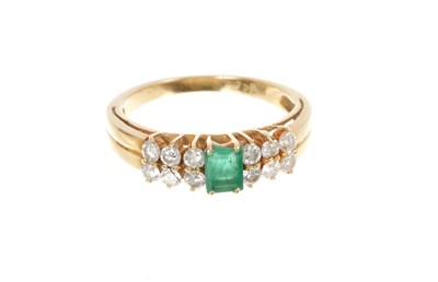 Lot 466 - Emerald and diamond ring with a step cut emerald flanked by twelve brilliant cut diamonds on tapered gold shank, stamped 750. Ring size K½.