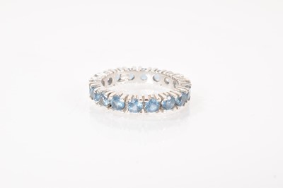 Lot 491 - Blue stone eternity ring in white metal setting, stamped 750. Ring size L.