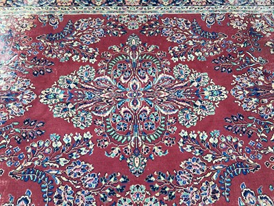 Lot 1509 - Large rug with floral decoration on red and blue ground, 264cm x 195cm