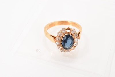 Lot 472 - Sapphire and diamond cluster ring with an oval mixed cut blue sapphire measuring approximately 8.6 x 6.2mm surrounded by a border of old cut diamonds, one stone loose. Ring size O.