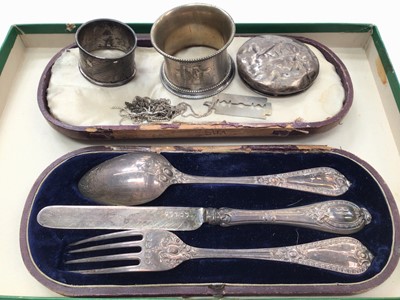 Lot 1057 - Silver knife, fork and spoon set in fitted case, two silver napkin rings, silver lid and chains