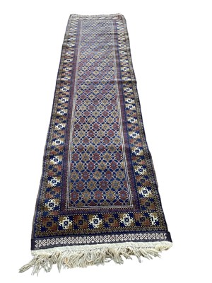 Lot 1430 - Eastern runner with geometric decoration on blue, red and brown ground, 309cm x 74.5cm