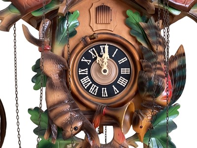 Lot 647 - Vintage Black Forest Cuckoo clock with Stag & crossed hunting rifle, game and horn decoration, Roman numeral dial and cone weights