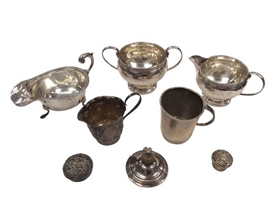 Lot 69 - Group of silver to include a sauce boat, two handled sugar bowl and matching jug, one other cream jug, christening mug and three lids