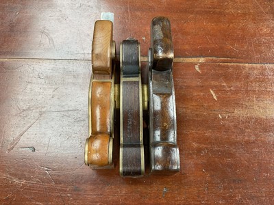 Lot 2445 - Three antique shoulder planes to include a bell metal/brass and yew wood plane, a brass and rosewood plane and a steel and wooden shoulder plane (3)