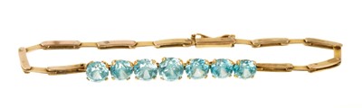 Lot 501 - Blue zircon and gold bracelet with seven graduated round mixed cut blue zircons in gold setting