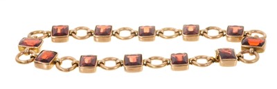 Lot 502 - Edwardian garnet bracelet with fancy cut cushion shape garnets in rose gold setting with circular gold links and invisible clasp
