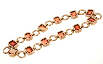 Lot 502 - Edwardian garnet bracelet with fancy cut cushion shape garnets in rose gold setting with circular gold links and invisible clasp
