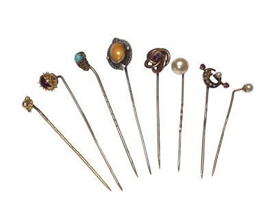 Lot 110 - Eight antique stick pins to include a Victorian 15ct gold ruby and seed pearl crescent moon pin