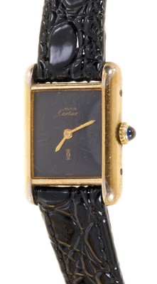 Lot 589 - Ladies Cartier Must de Cartier tank wristwatch with mechanical movement, black 'onyx' dial in silver gilt tank shaped case on leather strap. Service receipt from Cartier