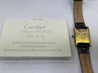 Lot 589 - Ladies Cartier Must de Cartier tank wristwatch with mechanical movement, black 'onyx' dial in silver gilt tank shaped case on leather strap. Service receipt from Cartier