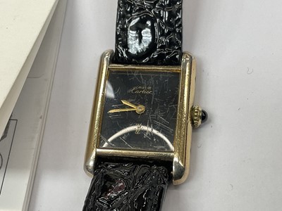Lot 589 - Ladies Cartier Must de Cartier tank wristwatch with mechanical movement, black 'onyx' dial in silver gilt tank shaped case on leather strap. Service receipt from Cartier