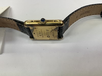 Lot 589 - Ladies Cartier Must de Cartier tank wristwatch with mechanical movement, black 'onyx' dial in silver gilt tank shaped case on leather strap. Service receipt from Cartier