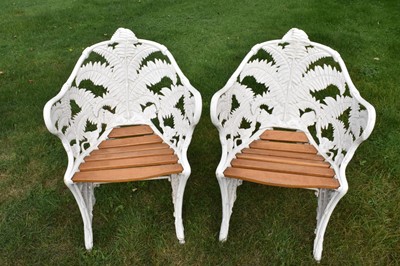 Lot 1255 - Pair of cast iron garden chairs, bowed form and in fern pattern, probably by Goss and Peene