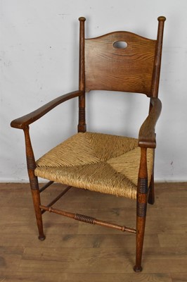 Lot 1273 - Arts & crafts oak elbow chair with rush seat