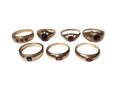 Lot 153 - Seven 9ct gold rings to include six single stone garnet rings and a three stone ring