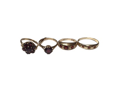 Lot 155 - 9ct gold garnet cluster ring, 9ct gold garnet single stone ring and two 9ct gold garent three stone gyspy set rings (4)