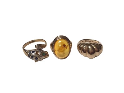 Lot 161 - 9ct gold diamond, sapphire and emerald set leopard head ring, 9ct gold polished amber ring and 9ct gold 'croissant' ring (3)