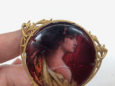 Lot 198 - Jean Baptiste Issanchou (1875 – 1960) Limoges circular enamel plaque depicting a classical maiden, 40mm diameter, in a French 18ct gold pendant/ brooch mount on gold chain, signed verso