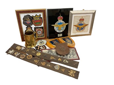 Lot 737 - Group of assorted Militaria to include cap badges, brass tankard made from shells from the battlefields of North Africa, regimental crests and other items (1 box).