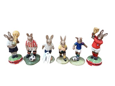 Lot 1287 - Six Royal Doulton Bunnykins figures to include four footballers and two holding trophies