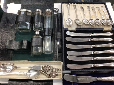 Lot 1084 - Silver topped glass vanity bottles in travel case, set of six silver handled butter knives in case, silver teaspoons and flatware